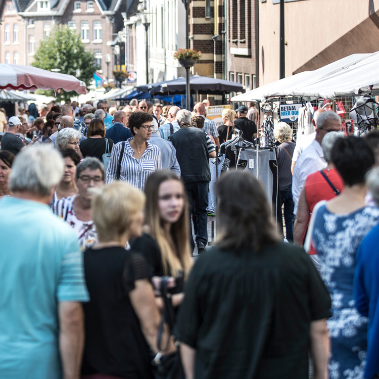 Veel mensen lopen langs kraampjes op de Jaarmarkt in Meerssen